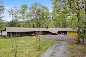 A two-story building with a sloped roof, a covered driveway, and a parking area. - Cosby Mountain Lodge 4 Bedroom Home (Cosby)