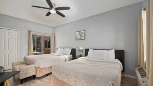 A bedroom with two beds, a ceiling fan, a desk, a chair, and a window. - Right Direction Rentals Studio Villa 8419 (Port St. Lucie)