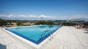 A rectangular swimming pool with a clear blue water surface, surrounded by a tiled deck. - Locanda Gulfi (Chiaramonte Gulfi)
