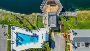 An aerial view of a resort with a swimming pool, a hexagonal building, and a parking area. - Boho Retreat 2003-Near Lake Aladdin-Sleeps 4 (Destin)