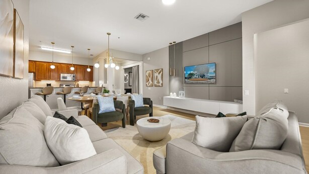 A modern living room with a dining area, kitchen, and a flat-screen TV mounted on the wall. - Upstay: Renovated Vista Cay Condo, Epic Universe (Orlando)