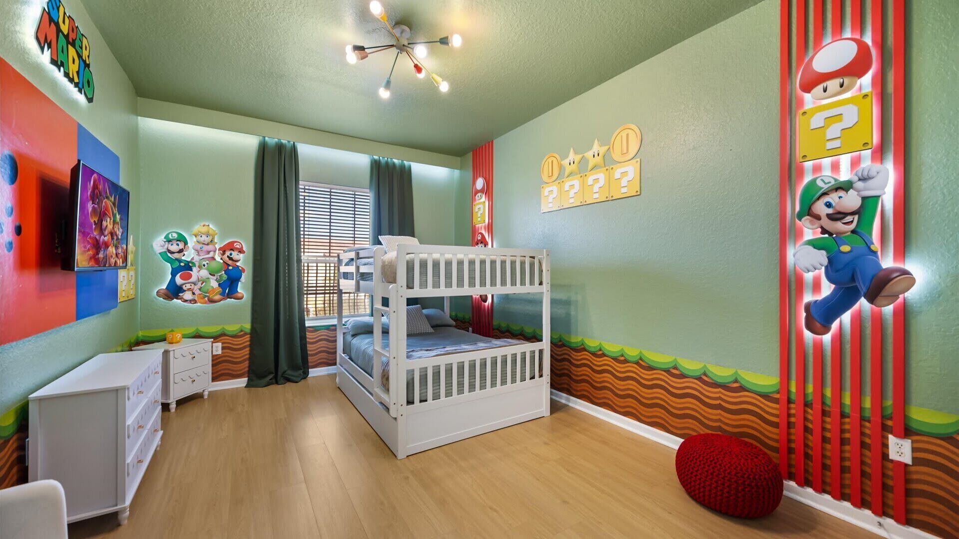 A child's bedroom with a bunk bed, Mario and Luigi wall art, and a Mario-themed ceiling light.