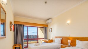A hotel room with two beds, a desk, a chair, and a balcony with a view. - #256 Sea & Sun View by Home Holidays (Portimão)