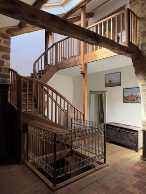 A wooden staircase with a wrought iron railing leading to an upper level. - Large medieval village house, pets welcome, private pool. (Salles)