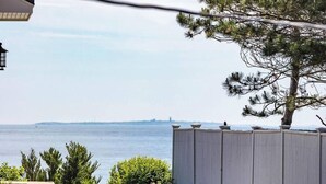 A residential property with a view of the ocean, a stone retaining wall, and a variety of shrubs and trees. - Ocean Boulevard North, 3 min walk to beach! (Rye)