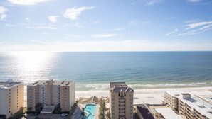 Un hôtel situé en bord de mer, composé de plusieurs bâtiments, doté d’une piscine et offrant une vue sur l’océan.