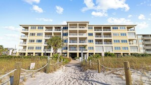 A beachfront hotel with multiple balconies, a sandy pathway, and a 'No Swimming' sign. - Marlin Key 3E by Liquid Life (Orange Beach)