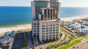 Un hotel moderno de muchas plantas, con estacionamiento y vistas a la playa.