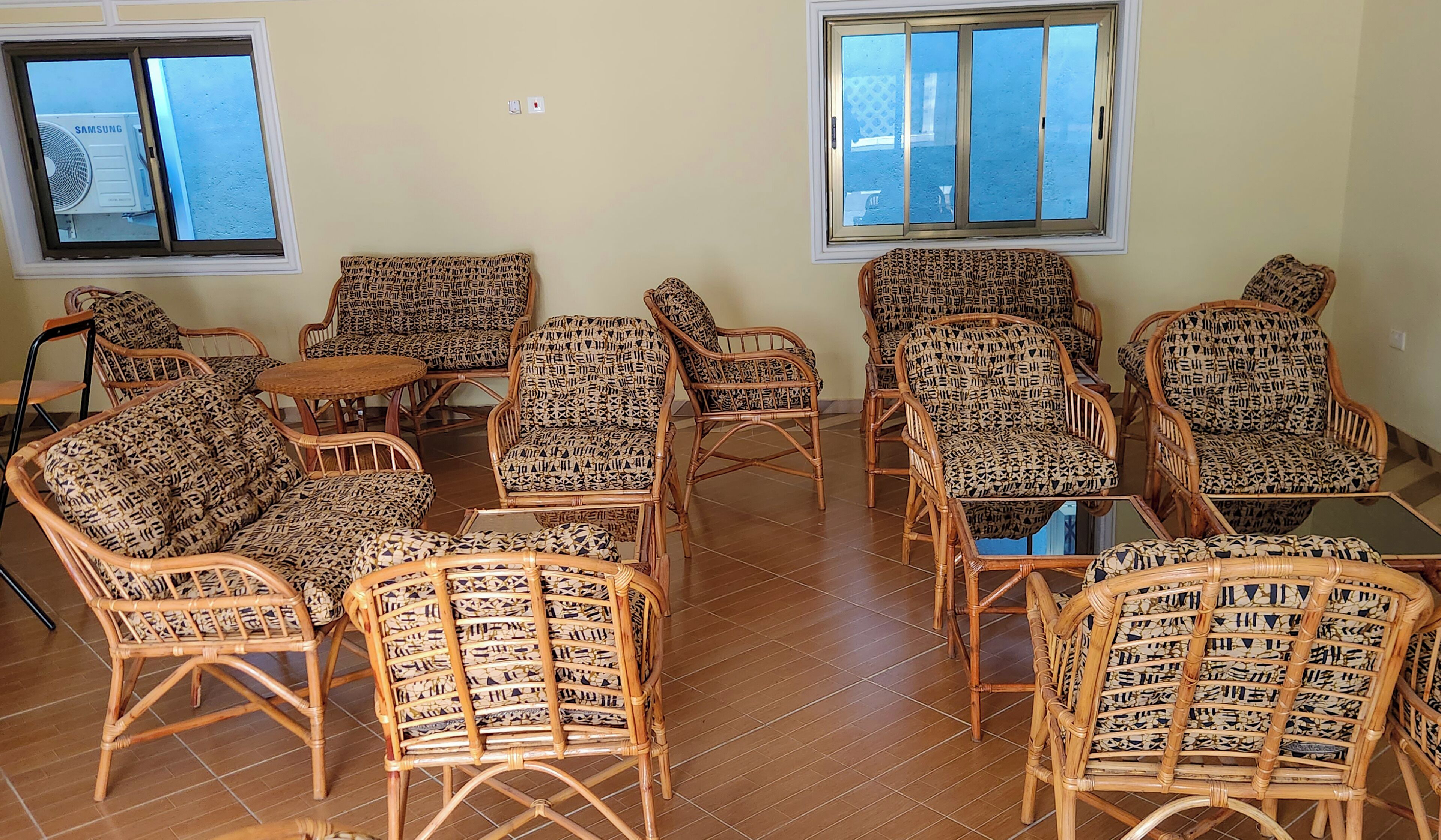A room with wicker furniture, including chairs and a small table, arranged around a central area.