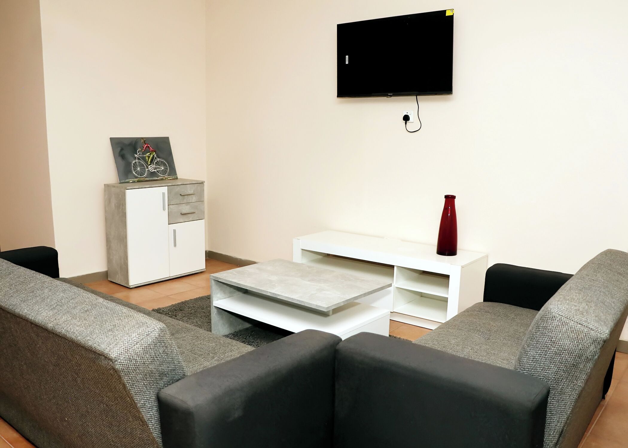 Een woonkamer met een bank, een salontafel, een televisie en een kast.