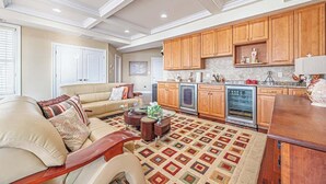 A spacious living room with a beige sofa, a coffee table, and a patterned rug.