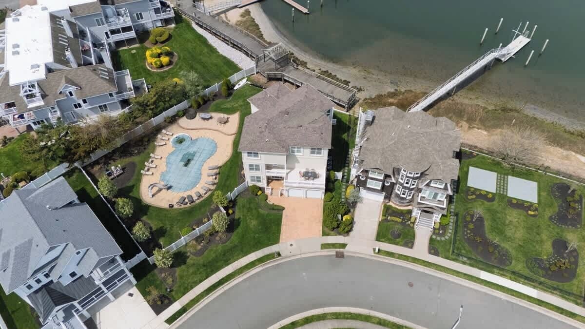 A residential area with a swimming pool, a dock, and a curved road.