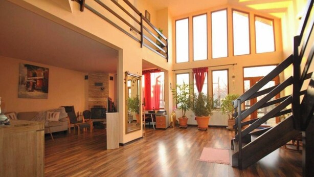A spacious living area with a wooden floor, a staircase, and large windows allowing natural light. - Pink Garden Events Advance Notice Required (Giarmata)
