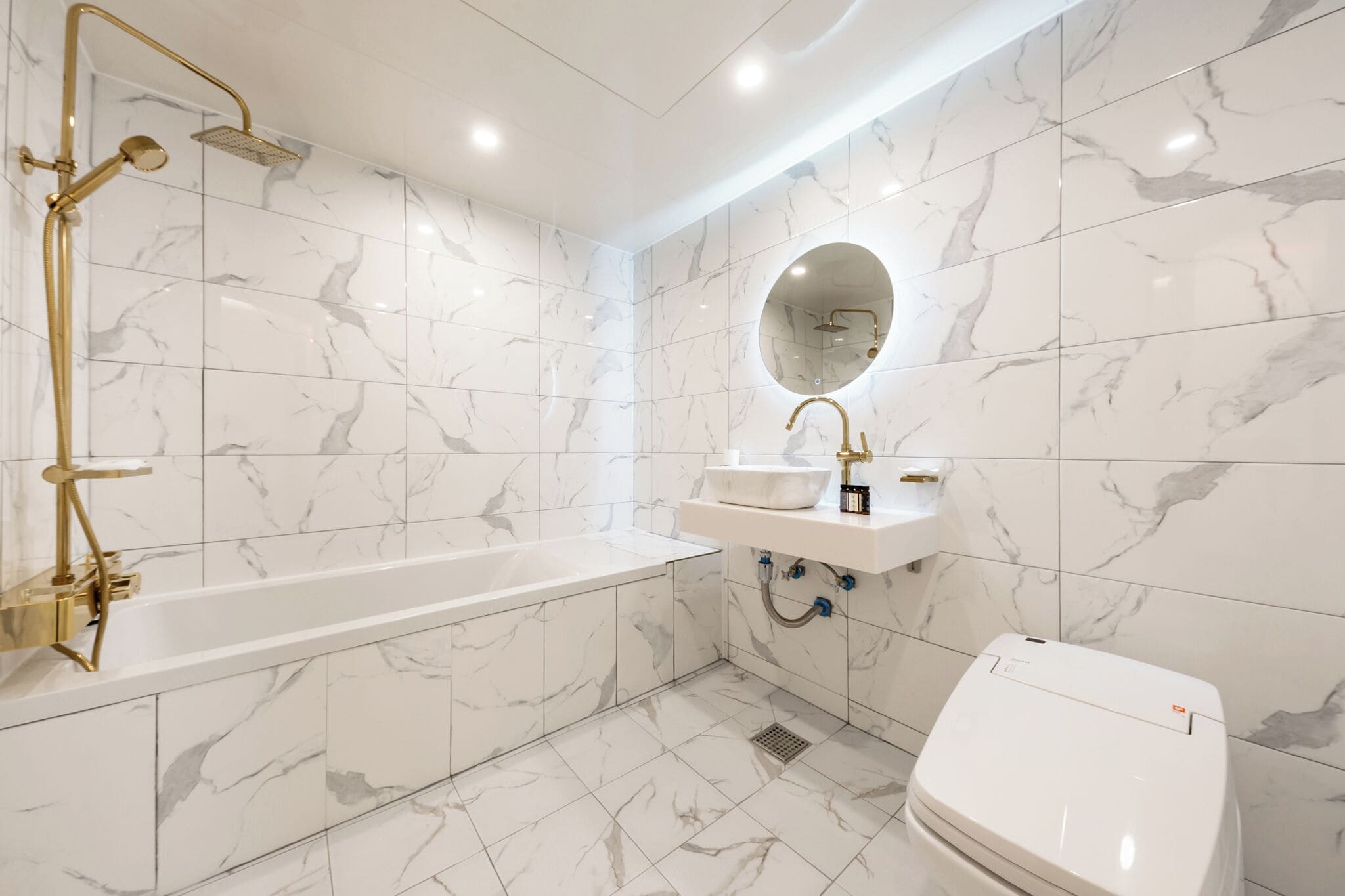 A modern bathroom with a bathtub, a sink, and a toilet.