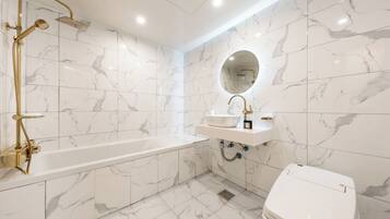A modern bathroom with a bathtub, a sink, and a toilet.