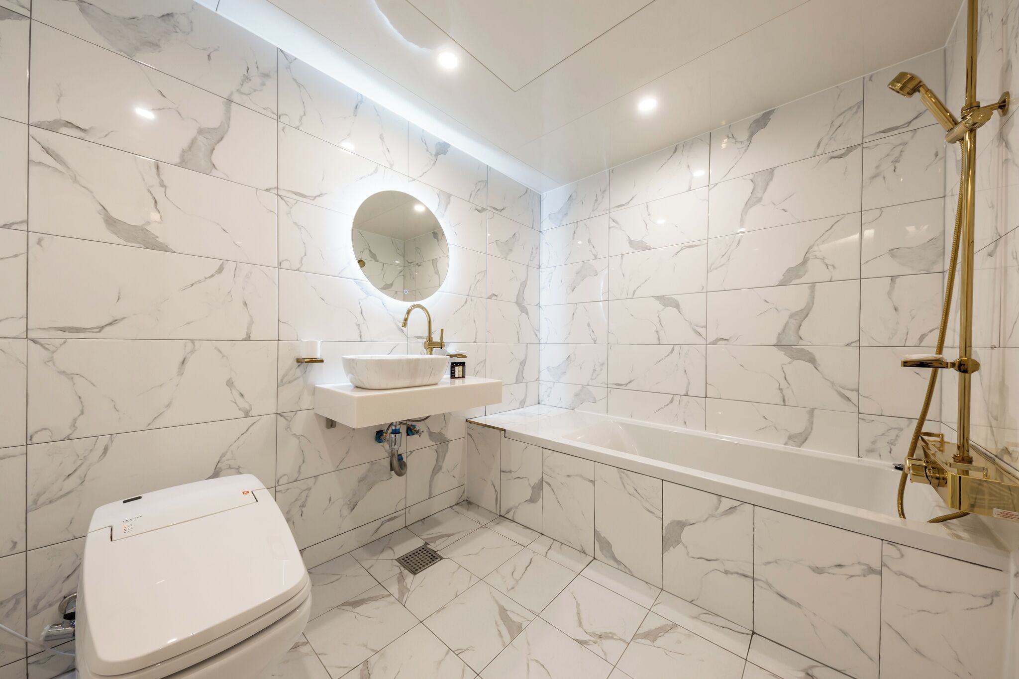 A modern bathroom with a toilet, sink, and bathtub.