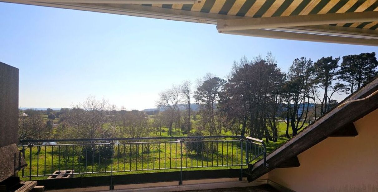 A balcony with a view of a green landscape and trees.