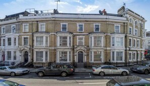 A row of terraced houses with a uniform architectural style, featuring symmetrical windows and a central entrance.