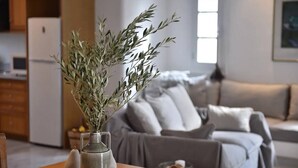 Un salon avec un canapé, une table basse et un vase décoré de branches.