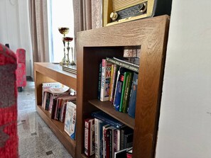 A bookshelf with various books and a radio. - West Gate (Sutomore)
