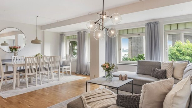Un salon moderne avec un canapé, une table basse et un coin repas.