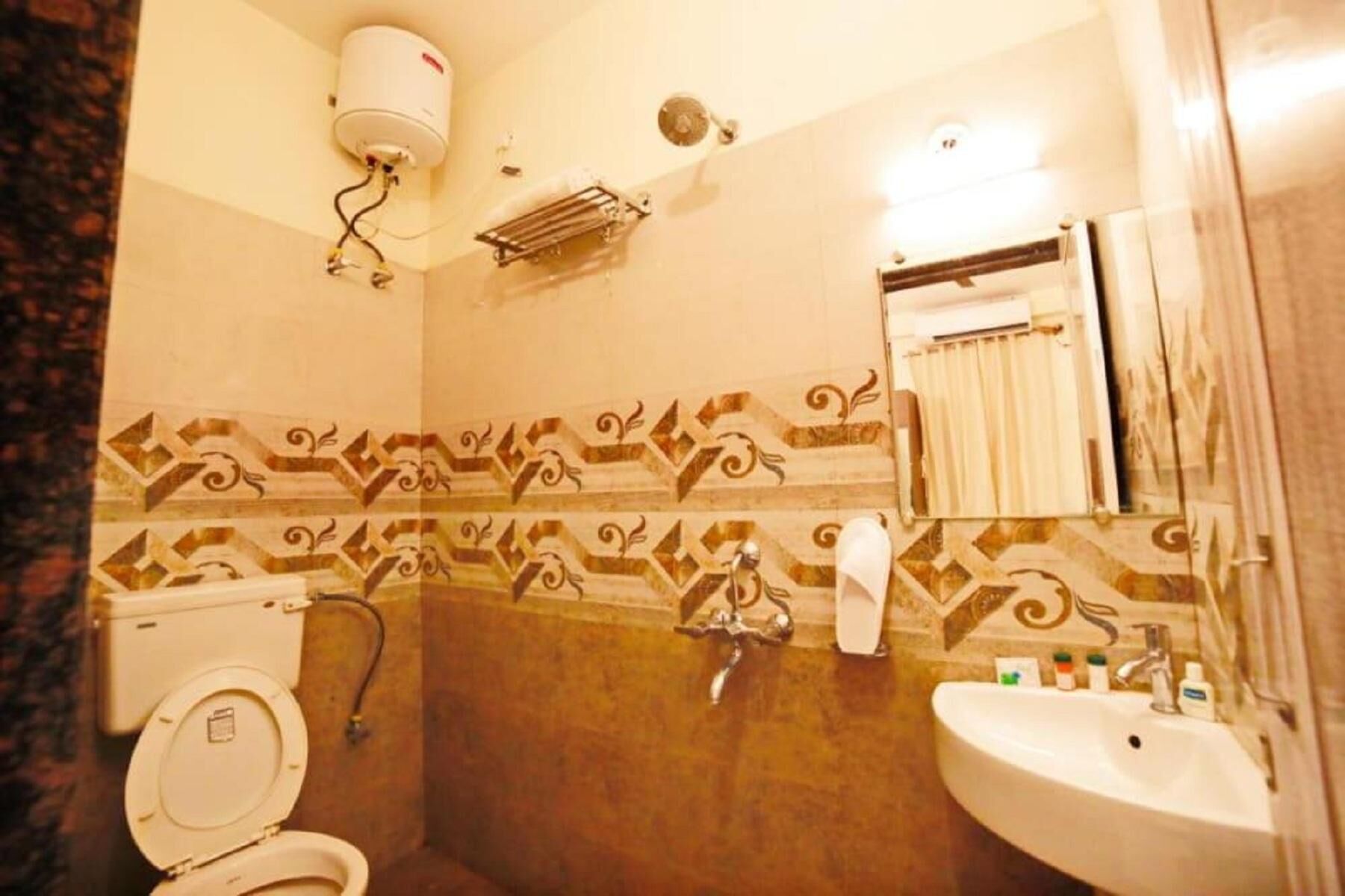 A bathroom with a toilet, sink, shower, and a towel rack.