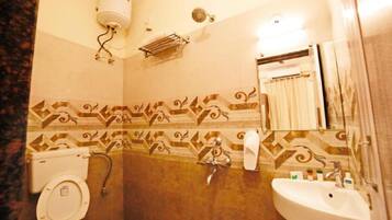A bathroom with a toilet, sink, shower, and a towel rack.