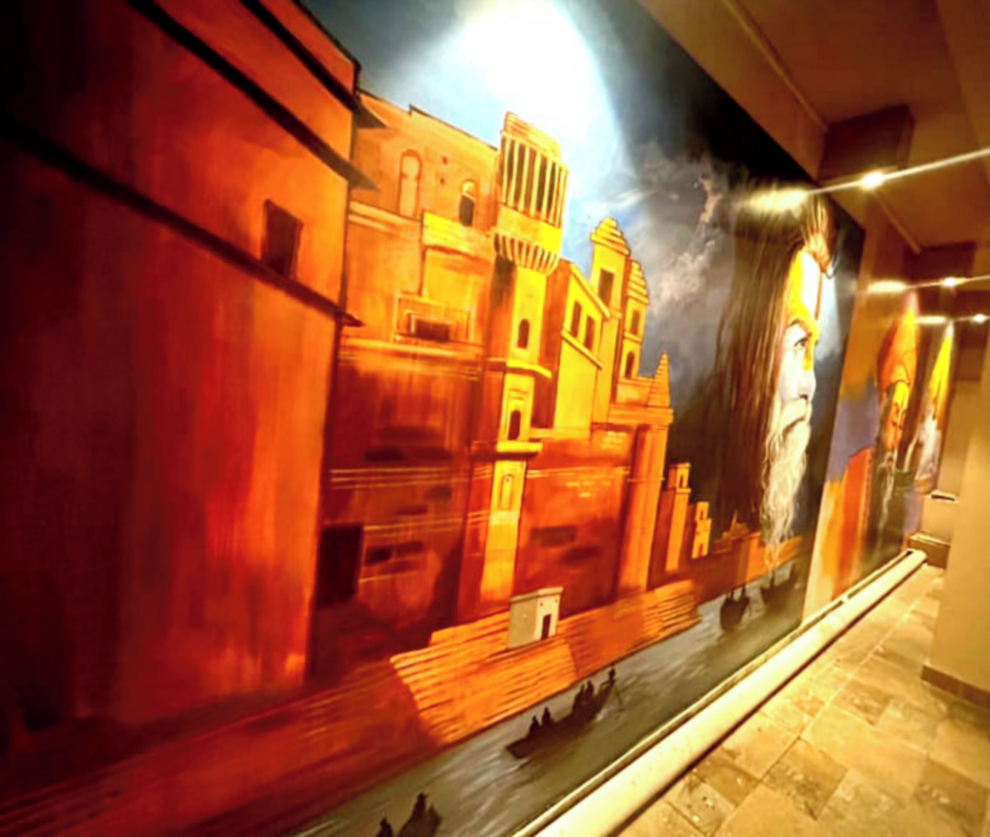 Un mural d'un paisatge urbà històric amb edificis i un riu.