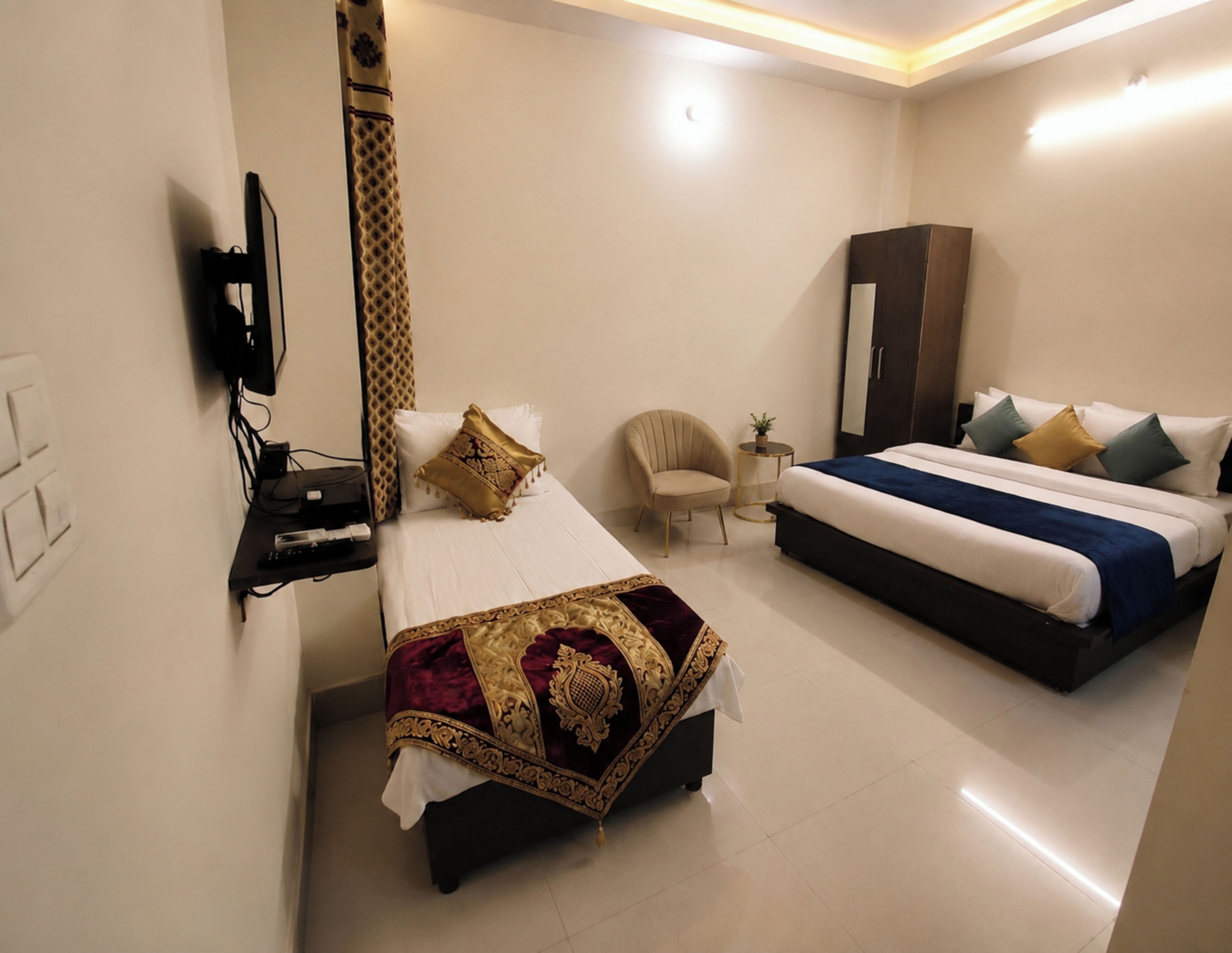 A hotel room with a bed, a chair, a wardrobe, and a television.