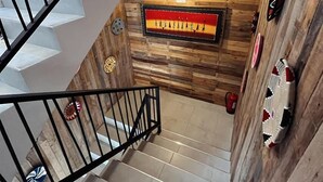 A staircase with a wooden wall and a modern light fixture. - Harmony surf lodge (Imi Ouaddar)