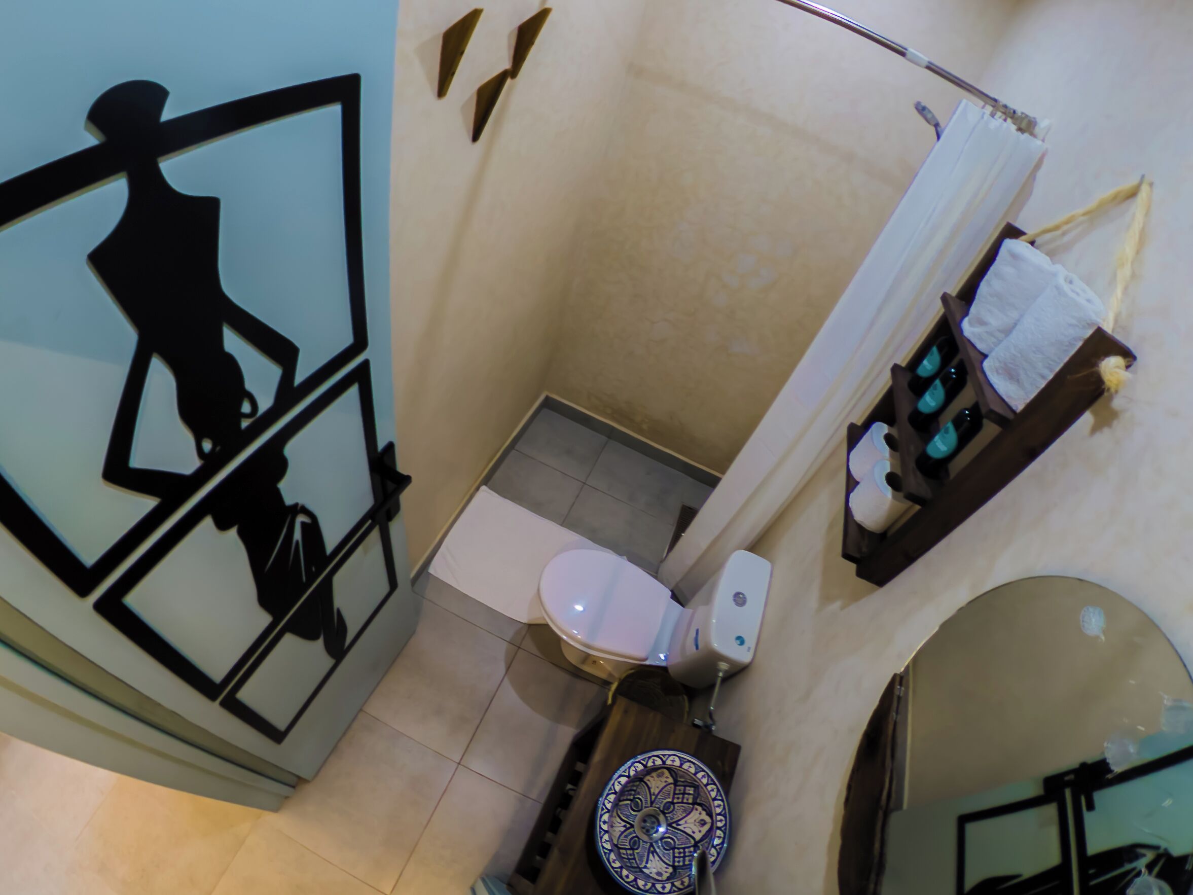 A bathroom with a toilet, a sink, and a shower area.