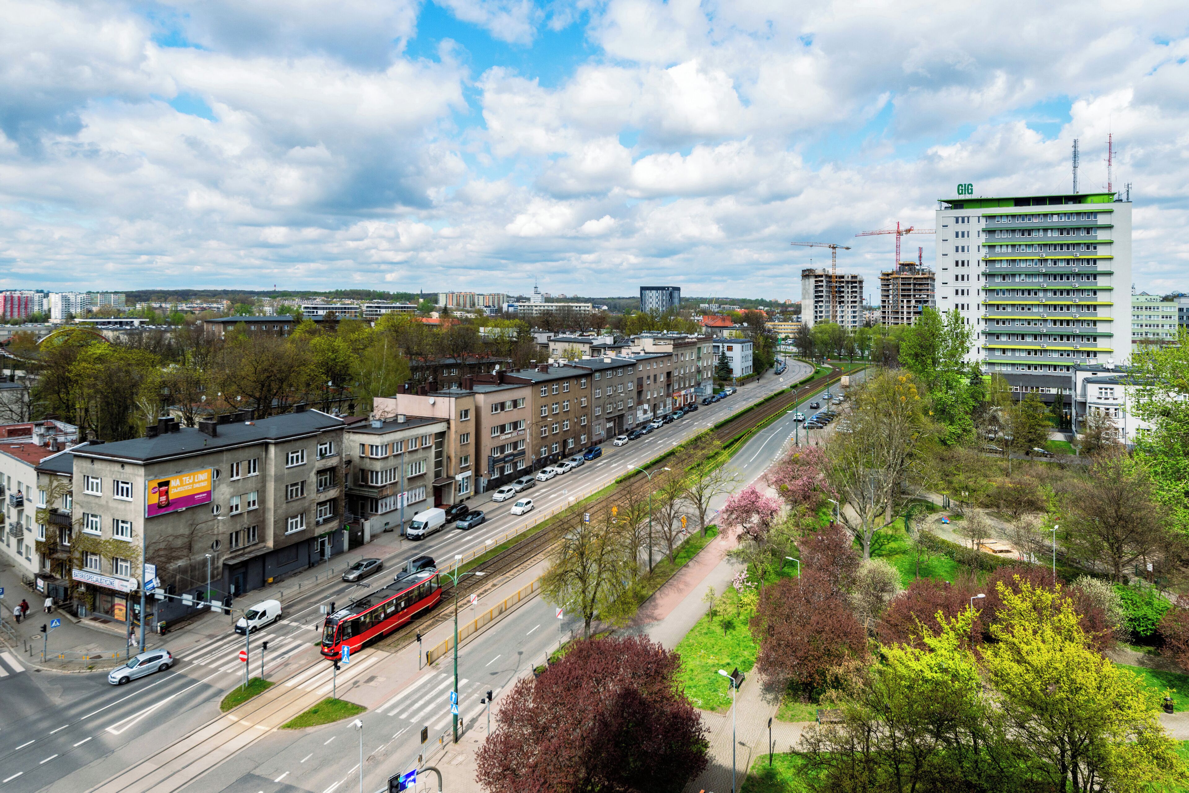 A cityscape with a tram, buildings, and a clear sky.