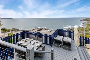 A deck with outdoor seating and a view of the ocean. - 5 Bed in Mortehoe (oc-s31791) (Mortehoe)