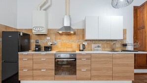 Una cocina moderna con horno empotrado, cafetera y hervidor.