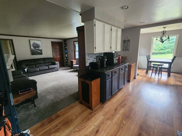 A modern kitchen with wooden cabinets and a dining area with a table and chairs. - Lake house, 2 bedroom, 2 bath in phenomenal Rhinelander on the Wi River Flowage (Rhinelander)