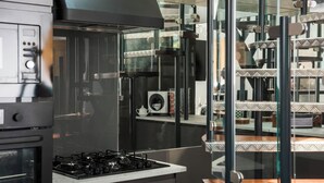 Una cocina moderna con estufa integrada, cafetera y armarios con puertas de vidrio.