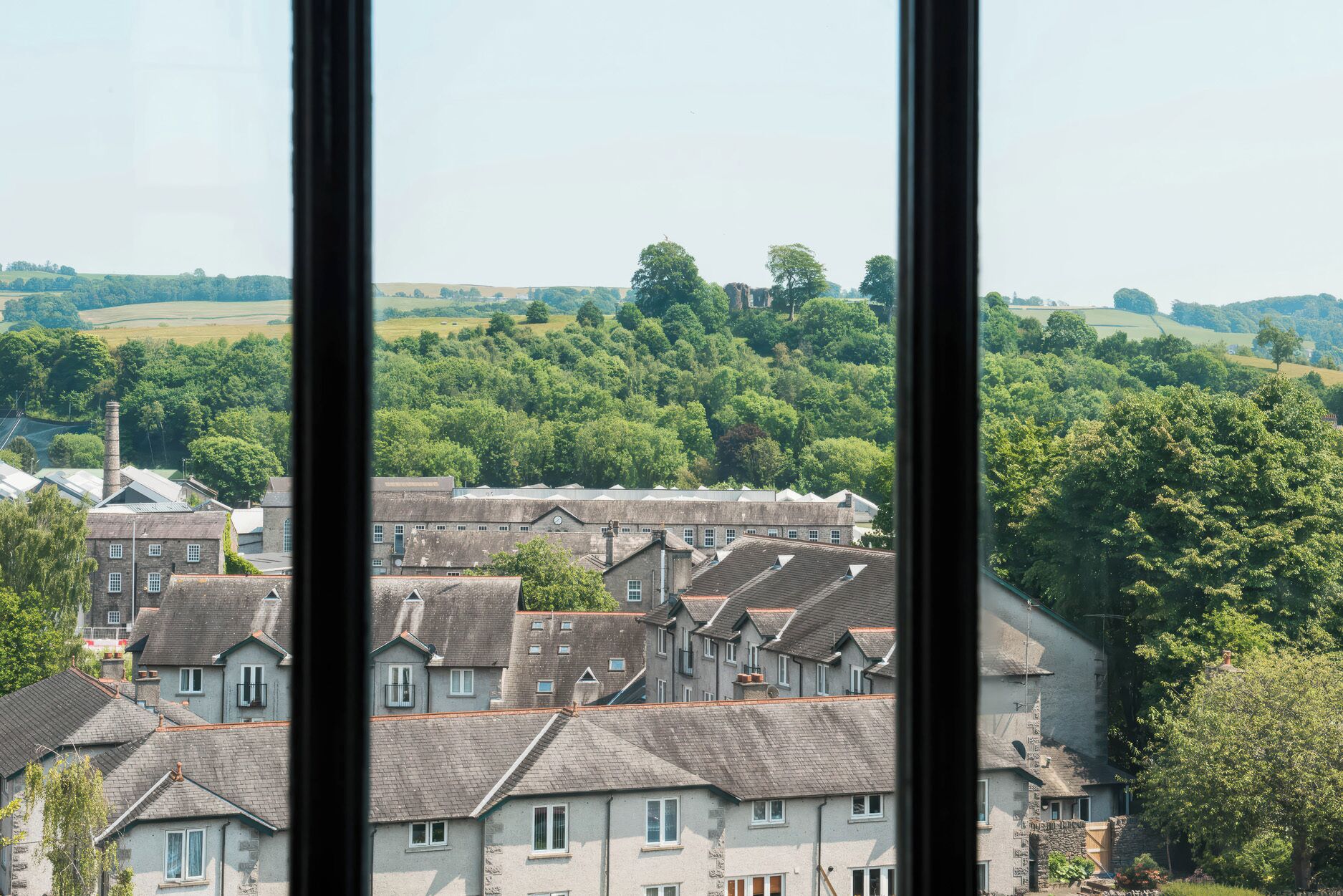Vista di una cittadina con edifici in pietra tradizionale e un mix di edifici residenziali e strutture industriali.