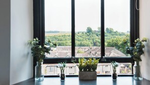 Une fenêtre donnant sur un quartier résidentiel, avec vue sur des maisons et des espaces verts.