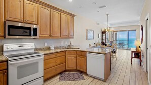 A modern kitchen with wooden cabinets, a built-in microwave, a stove, and a dishwasher.