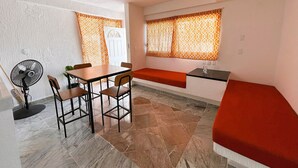 A compact room with a dining table and chairs, a small kitchen area, and a bench. - Ocen view spacious villa (Acapulco de Juárez)