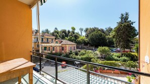 Un balcone con vista su un cortile, un tavolo e un canestro da basket.