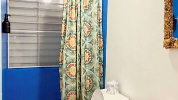 A bathroom with a toilet, sink, and shower curtain.