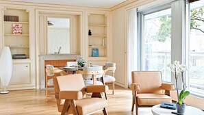 Una sala de estar moderna con chimenea, zona de comedor y un ventanal con vistas.