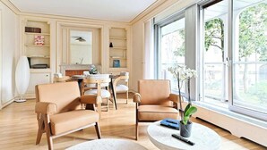 Una sala de estar moderna con un sofá, sillas, una mesa de centro y un ventanal con vistas.