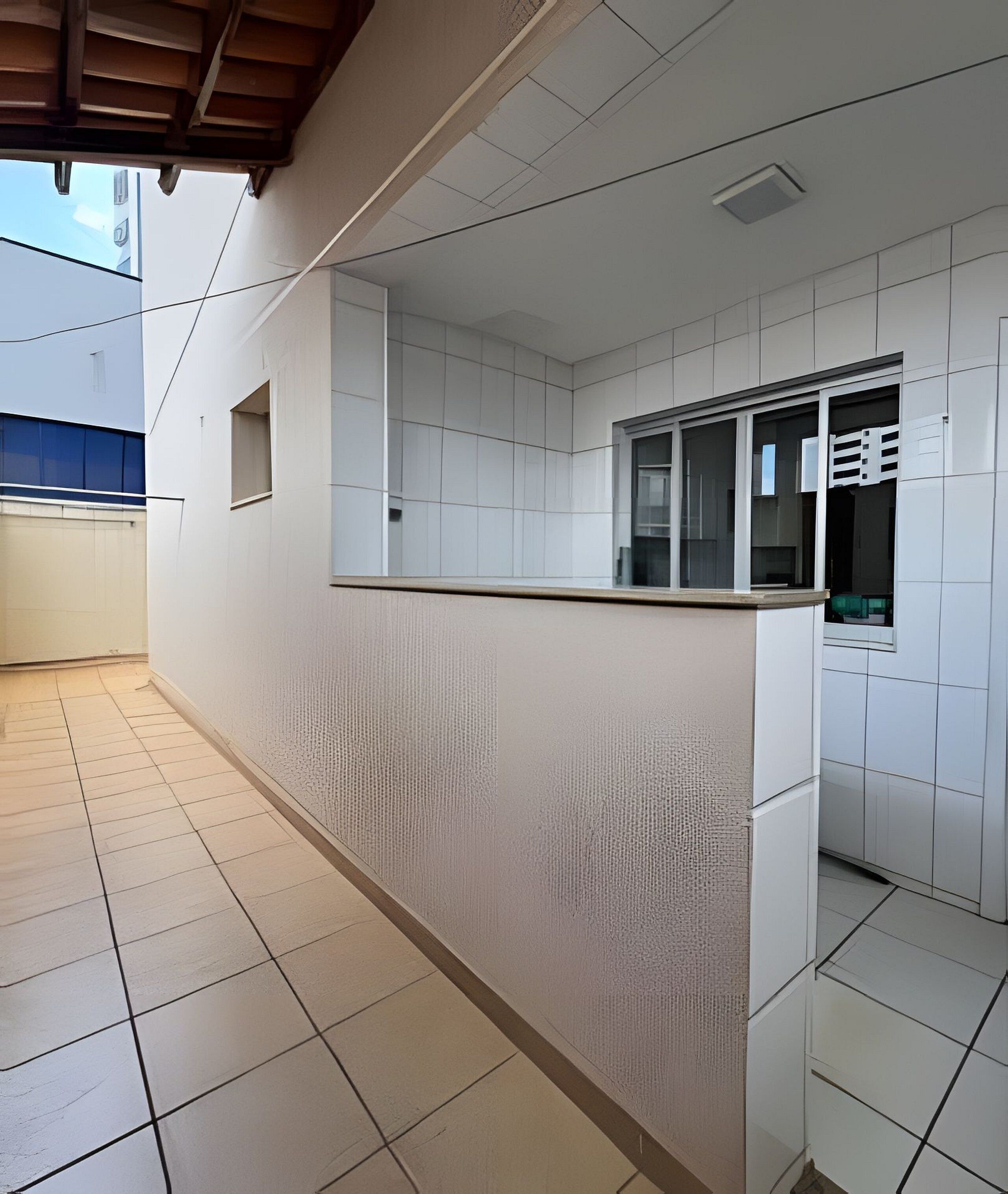 Ein Flur mit Fliesenboden, weißen Wänden und einem Fenster mit Jalousien.