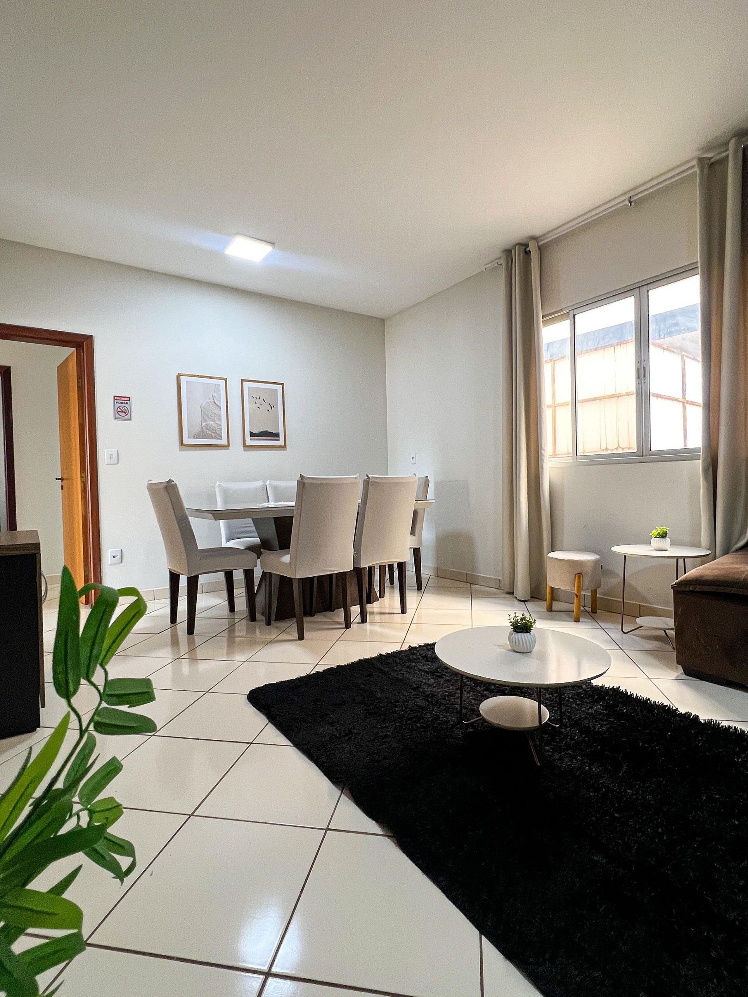 Un salon moderne avec un coin repas, comprenant un tapis noir, une table basse ronde et un canapé.