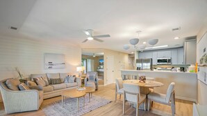 A modern living room with a sofa, coffee table, and dining area.