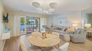 A modern living room with a round table, sofas, and a ceiling fan.