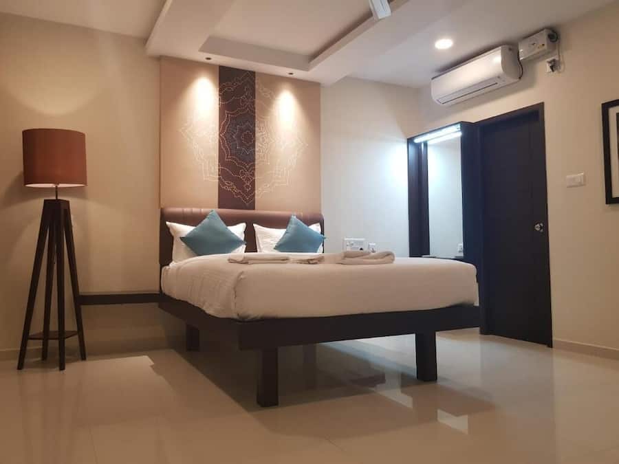 Una habitación de hotel moderna con una cama grande, una lámpara de pie y un panel decorativo en la pared.