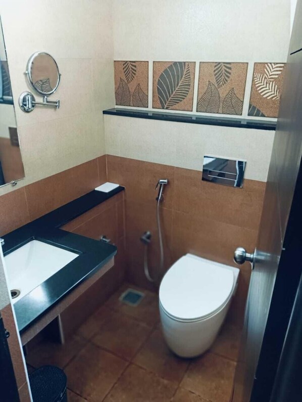A compact bathroom with a sink, toilet, and shower. - The Bull Boutique Hotel (Puducherry)